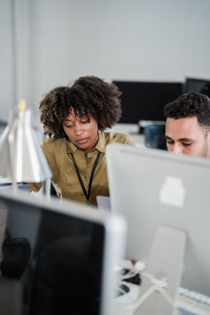 core-values Two colleagues work together in a modern office setting, focusing on a project.